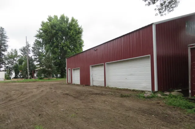 After: Bare graded ground beside a red three-door garage
